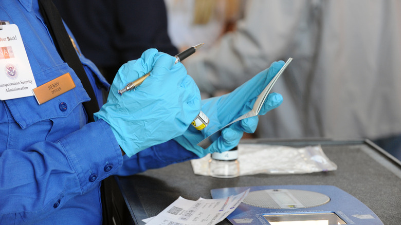A TSA officer checking a passport
