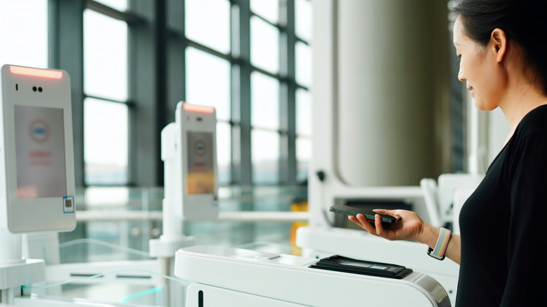 A woman scanning her information at a biometric airport