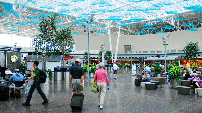 Interior view of Indiana International Airport, Indiana, United States, with travelers walking through it and waiting around