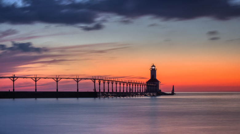 The Washington Park lighthouse silhouette with a deep orange sunset in the background