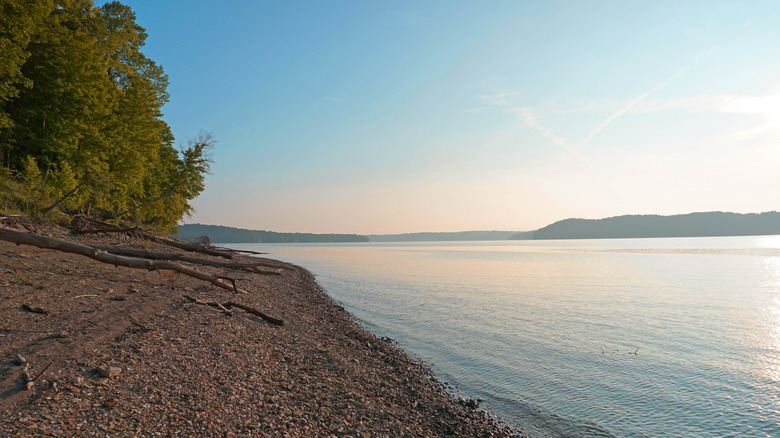 A beach at Lake Monroe with blue skies and a coarse sandy shore