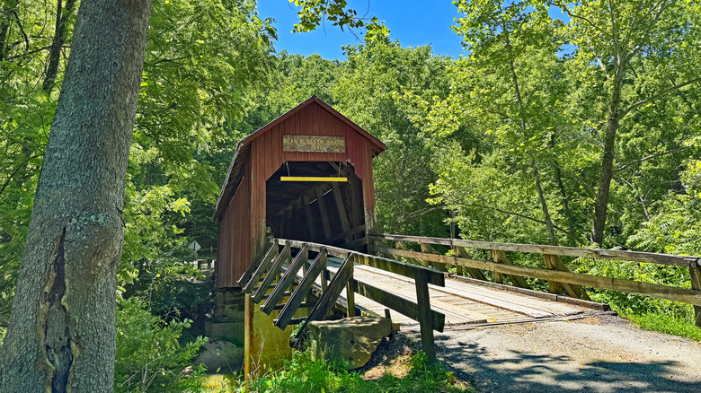 The red covered bridge known as Bean Blossom Bridge in Brown County, Indiana, positioned over a cool stream