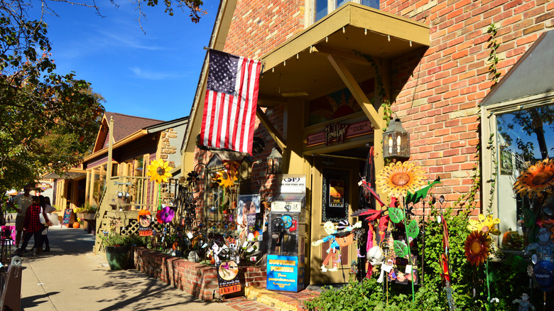 Brickhouse storefronts in Nashville, Indiana with sunflower decor, an American flag and items for sale on the sidewalk