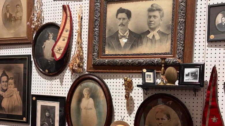Black-and-white photos in antique frames hanging on a wall in Exit 76, Indiana