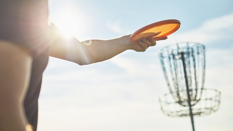 person getting ready to score in disc golf