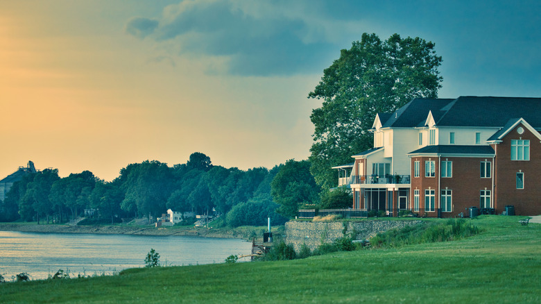 The Ohio River coursing past trees and houses along the riverbank in Newburgh, Warrick County.
