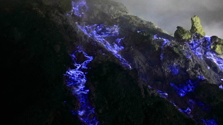 Blue sulfur flames burning on the volcanic rocks at Mount Ijen in Indonesia.