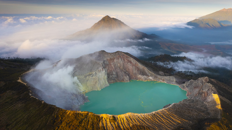 Mount Ijen's crater rim and sulfur lake at sunrise.