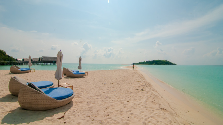 The beach at Bawah Reserve with loungers and bungalows in backdrop