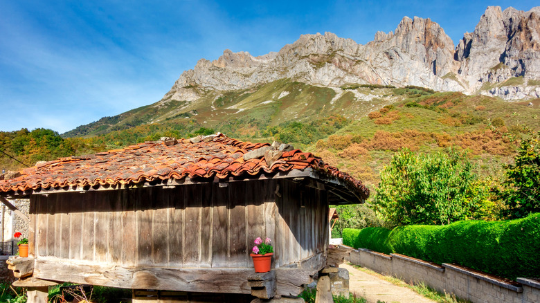 A traditional horreo structure and the Picos de Europa mountains in Posada de Valdeon, Valdeon Valley, Leon, Spain