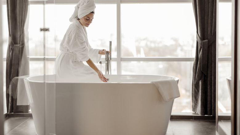 A woman filling a bath in a hotel