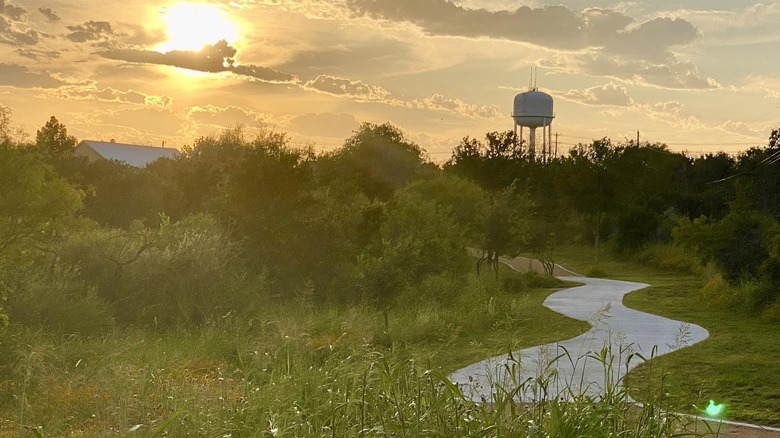 Sunset over a park with a water tower in the background in Iowa Colony.