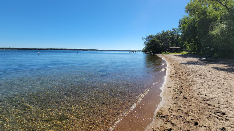 The long sunny, sandy beach and clear water at Gull Point State Park in Iowa