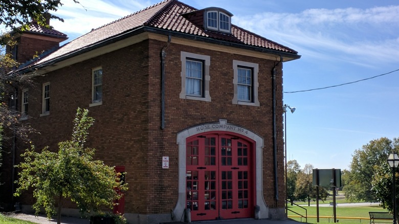 A 1900s brick fire house with a red paned door