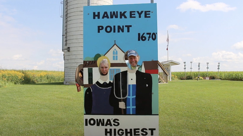 People posing in American Gothic cutout at Hawkeye Point, Iowa.