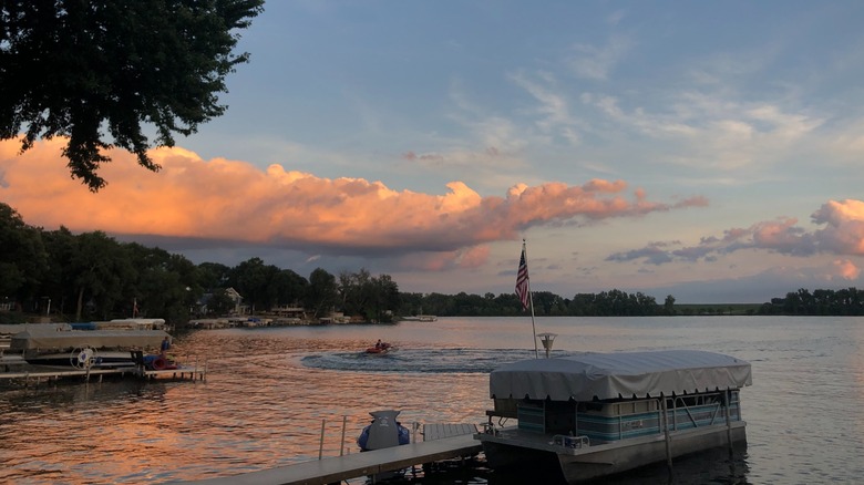 Sunset over Black Hawk Lake, Black Hawk State Park, Iowa, with a dock, boats, and the US flag