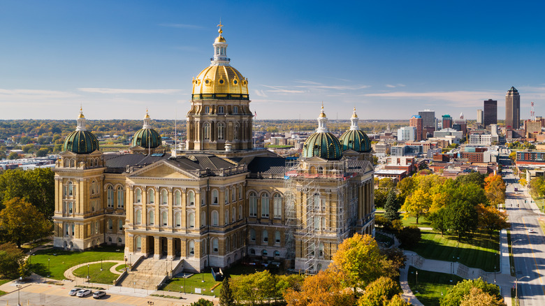 Iowa State Capitol building with Des Moines skyline in the background on a clear day
