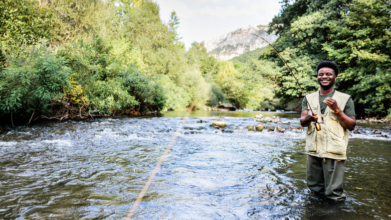 Fisherman fly fishes for trout