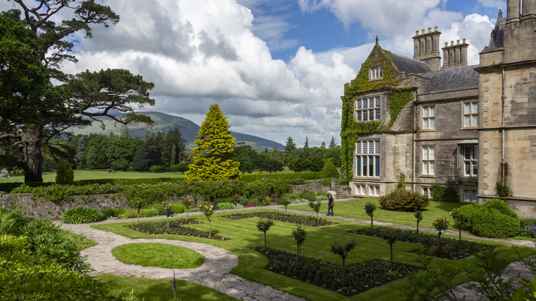an ivy-covered Victorian mansion and its manicured gardens