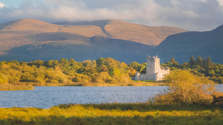 golden hour on a lakeside castle in Killarney National Park, Ireland