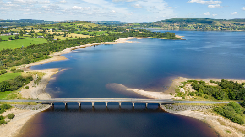 An aerial view of a highway bridge over the Poulaphouca Reservoir on a sunny summer day in Ireland