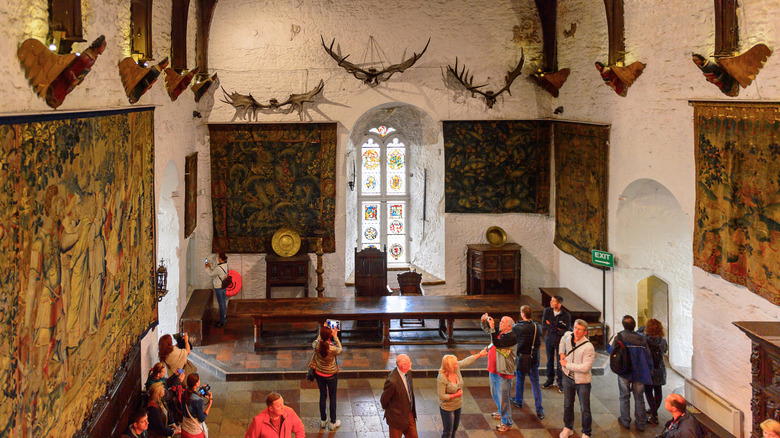 The Great Hall in Bunratty Castle with tourists taking pictures