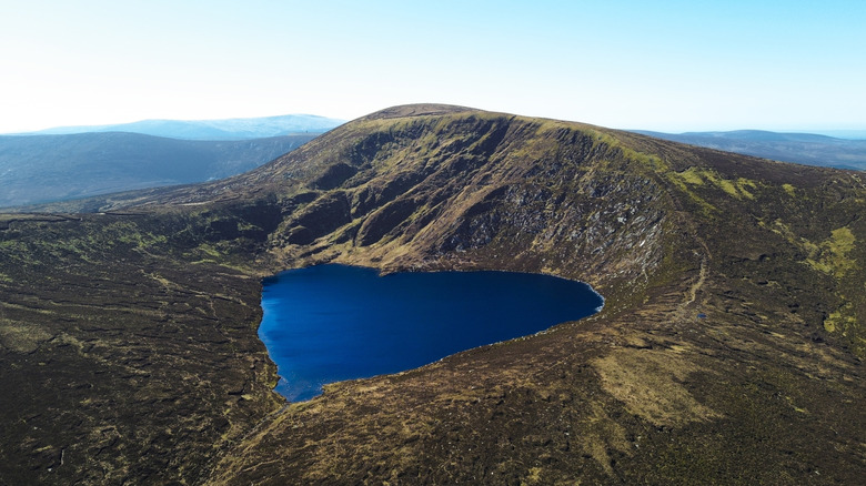 Aerial view of the heart-shaped lake, Lough Ouler in Ireland, surrounded by mountains on a clear day