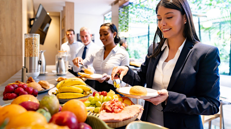 Travelers getting breakfast at a hotel breakfast buffet