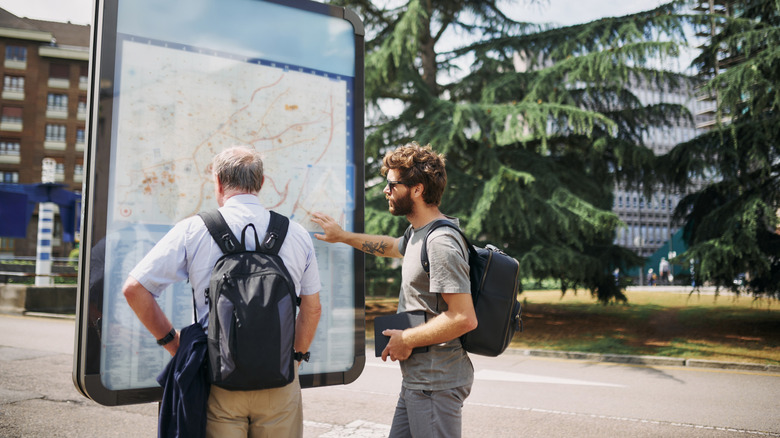 Father and son travelers consulting a street map