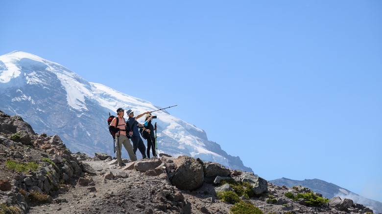 Hikers crest trails in Cascades with Mount Rainier in background
