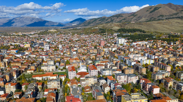 Aerial view of Korca, Albania, full of buildings, running to bald mountains in background