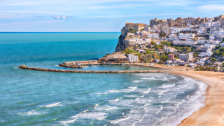 View of beach and whitewashed Peschici buildings on the hillside
