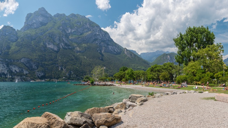 Mountains overlook the pebble beaches of Lake Garda