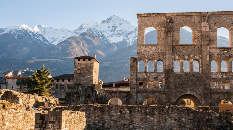 View of Roman theater with snow-capped mountains in background in Aosta Valley, Italy
