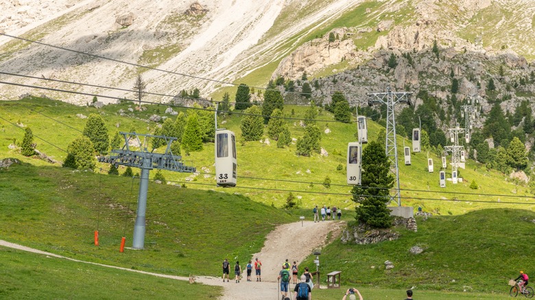 The coffin gondolas make their loops above the valley to Sassolungo Mountain in the Dolomites