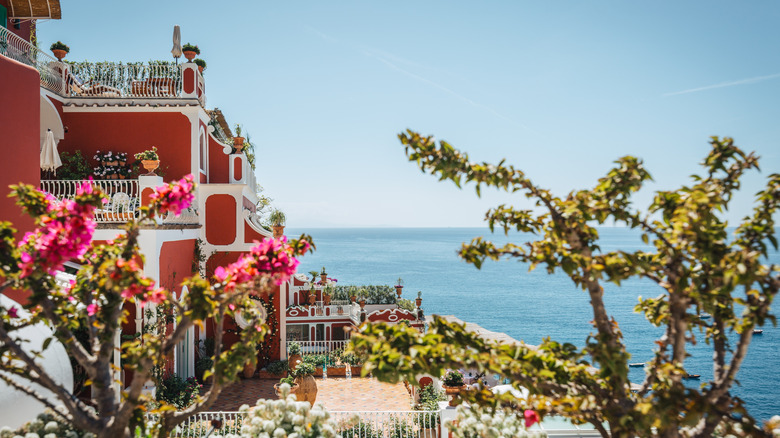 View of Positano's coastline and the striking red facade of Le Sirenuse hotel