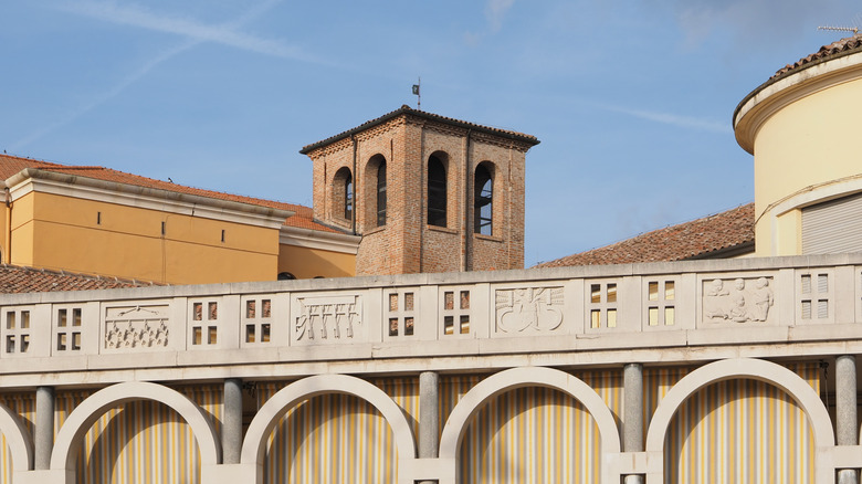 Romanesque bell tower in the background of a modern colonnade in Tresigallo, Italy