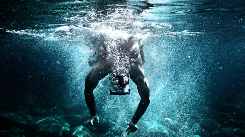 A man dives into the clear waters off Palmarola in Italy