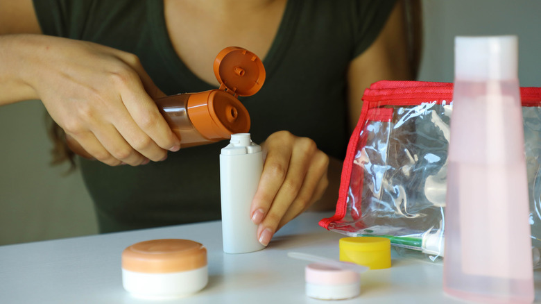 Woman holding mini toiletries and passport