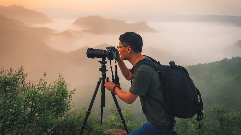 Photographer using camera on tripod