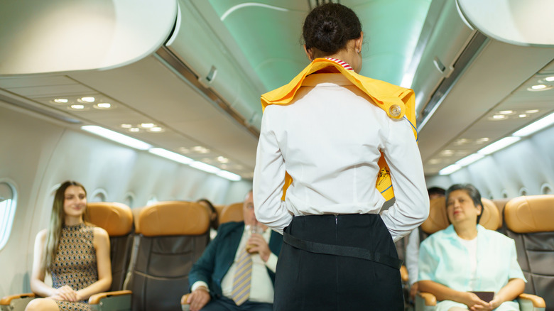 Flight attendant performing a safety demonstration