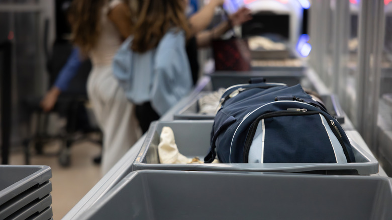 A backpack waits to go through the X-ray scanner at the airport.
