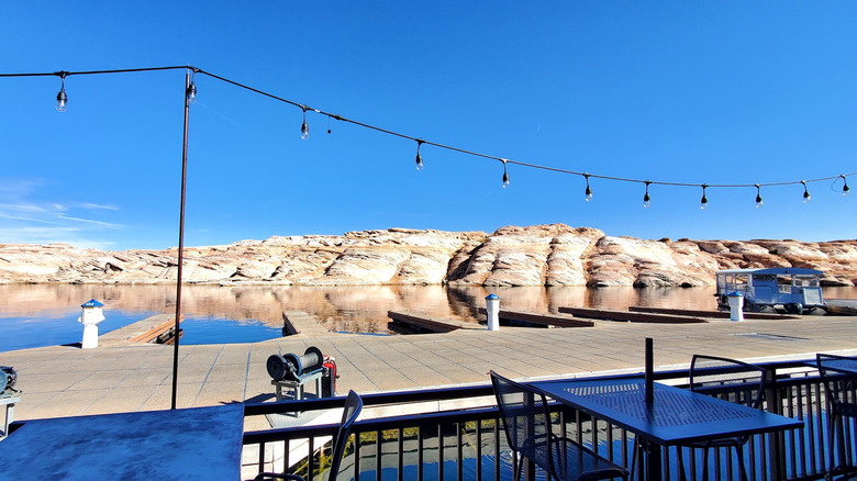 tables on outdoor patio next to pier with red rock scenery in background
