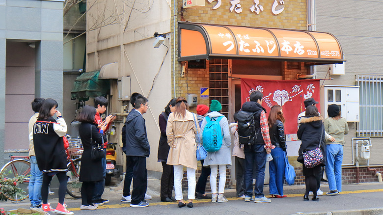 Line of people waiting to enter a ramen shop in Japan