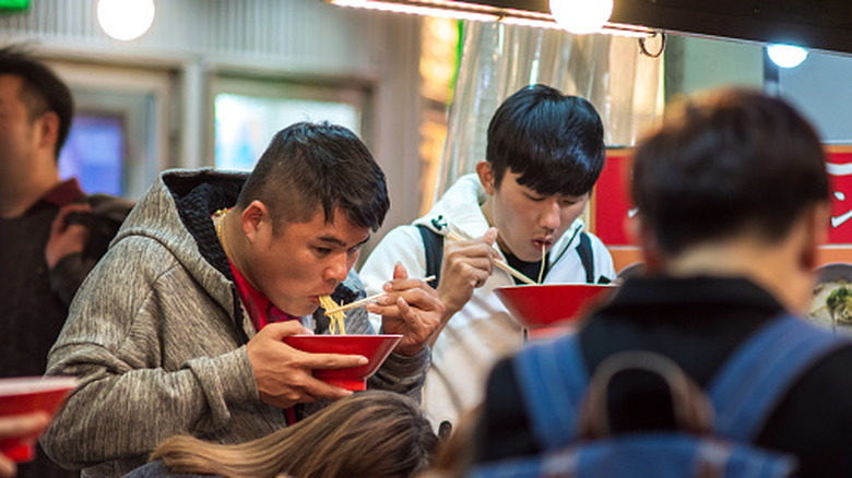 Several men eating ramen at a restaurant in Japan