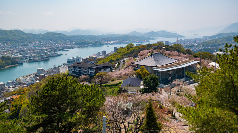 A hilltop temple surrounded by cherry blossom overlooks Onomichi, islands, and the Seto Inland Sea