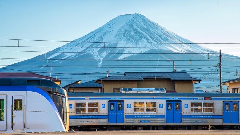trains passing in front of Mount Fuji