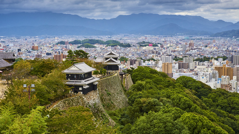 An aerial view of Matsuyma with walls and turrets of Matsuyama Castle in foreground