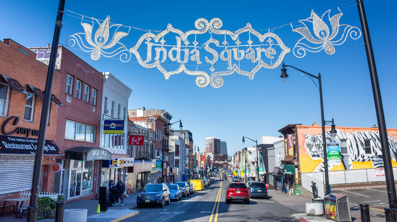 Street in Journal Square with small shops, under the sign "India Square"