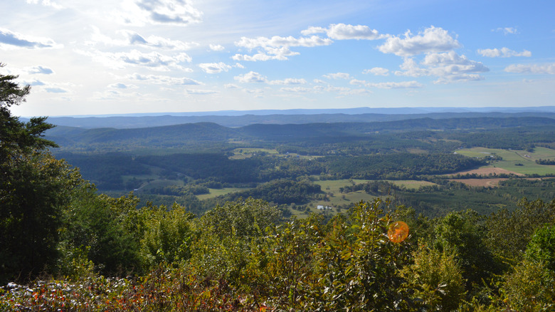The view from the top of John's Mountain covering valleys, farms, forests, and distant mountains.